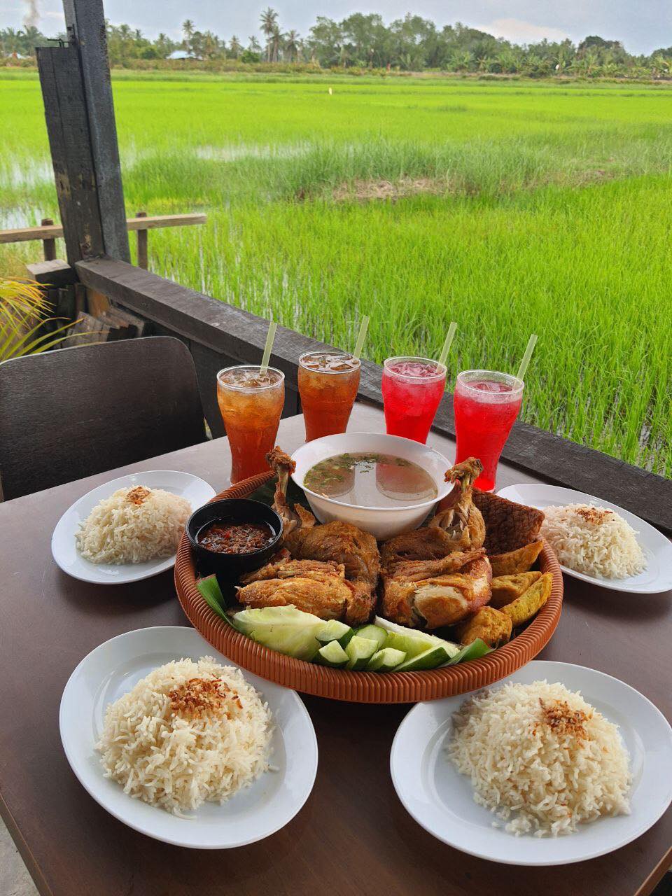 Makanan yang enak disajikan bersama dengan pemandangan sawah padi yang indah.